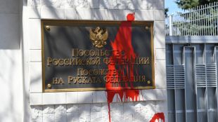 Червена боя върху оградата и табелата на руското посолство в