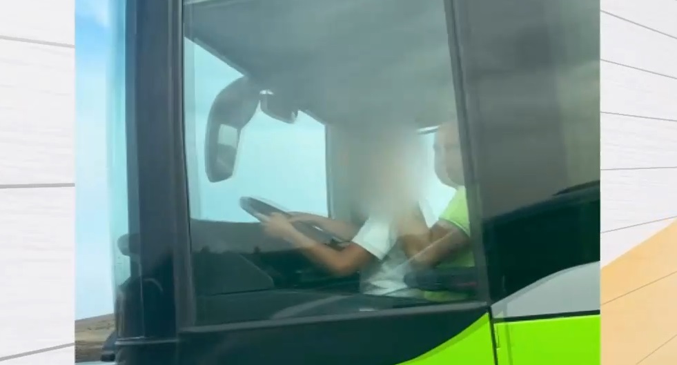 Момче седи върху скута на шофьор на автобус, пълен с пътници (ВИДЕО)